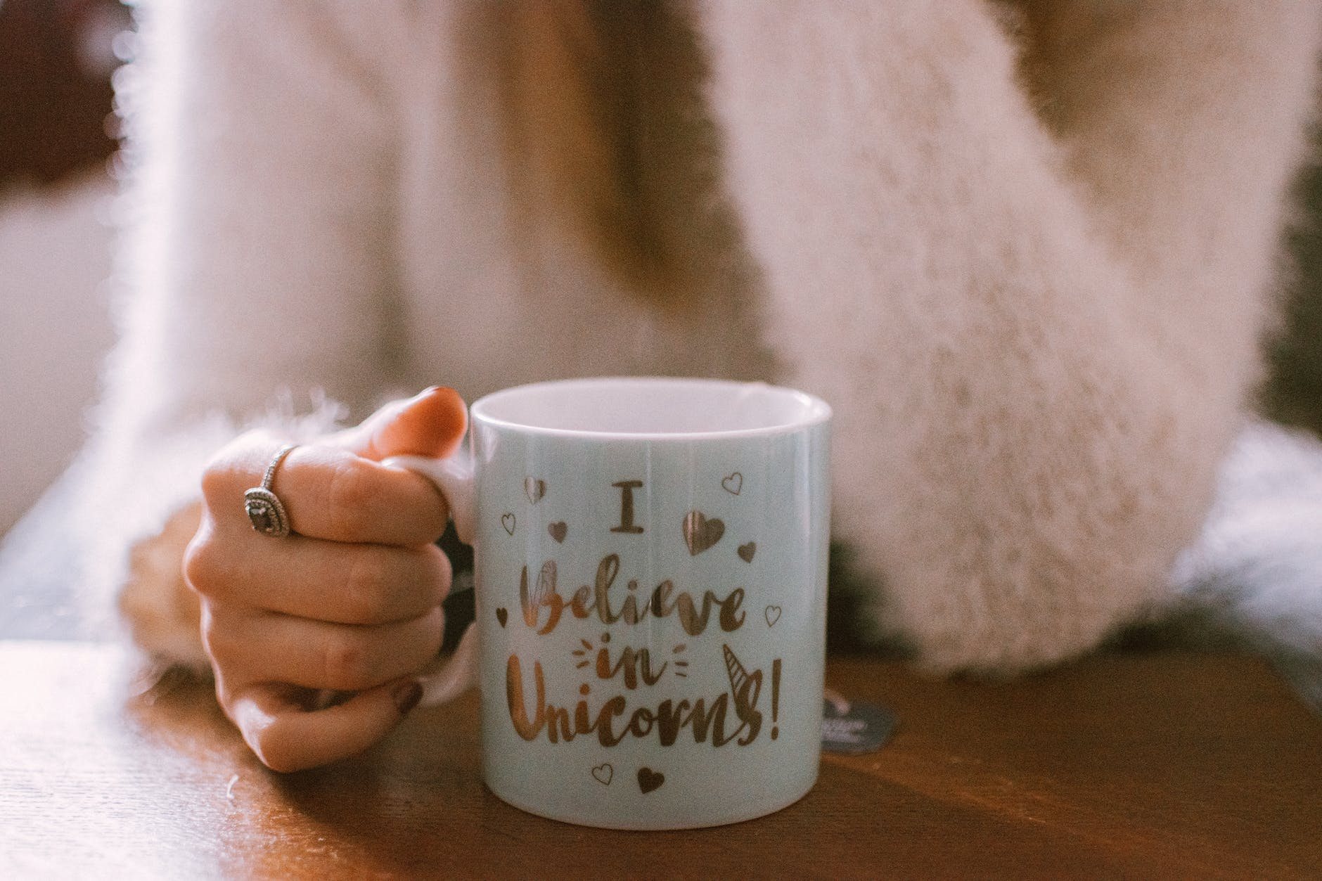 selective focus photography of person holding mug